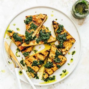 grilled triangles of tofu with chimichurri sauce and oil drizzled about.