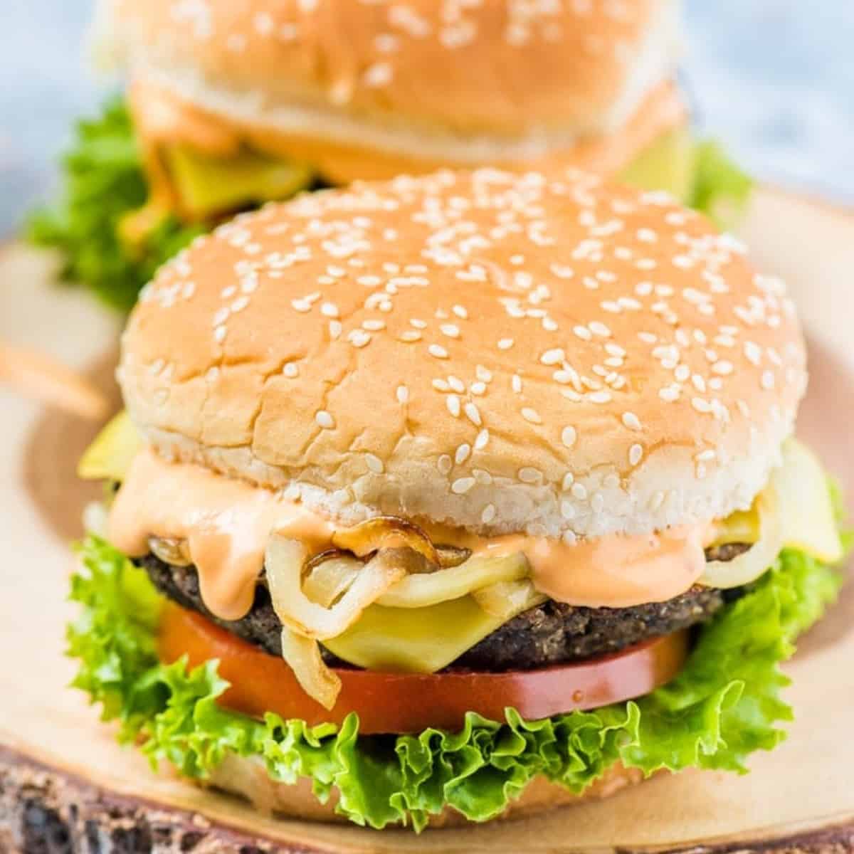 sesame seed buns with burger and toppings.