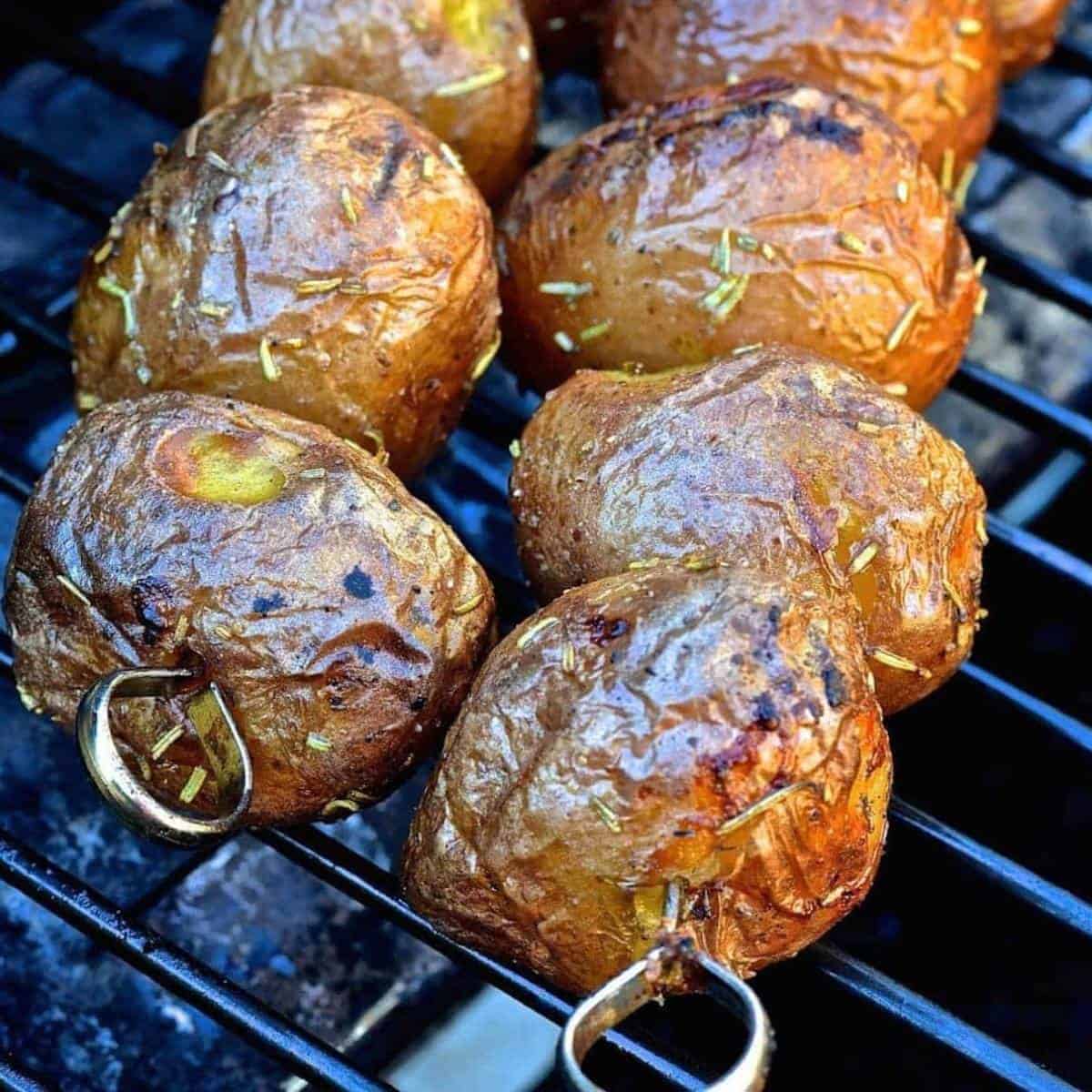 baby potatoes on skewers on a grill.