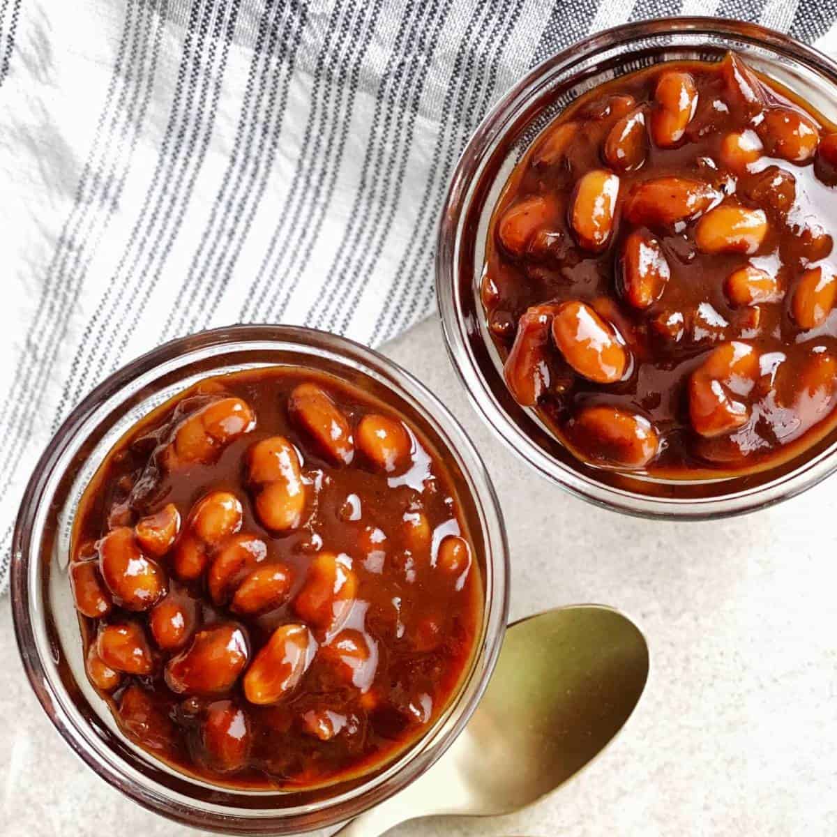 baked beans in glass bowls with a spoon.