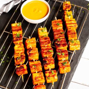 grilled tofu skewers with sauce on grate.