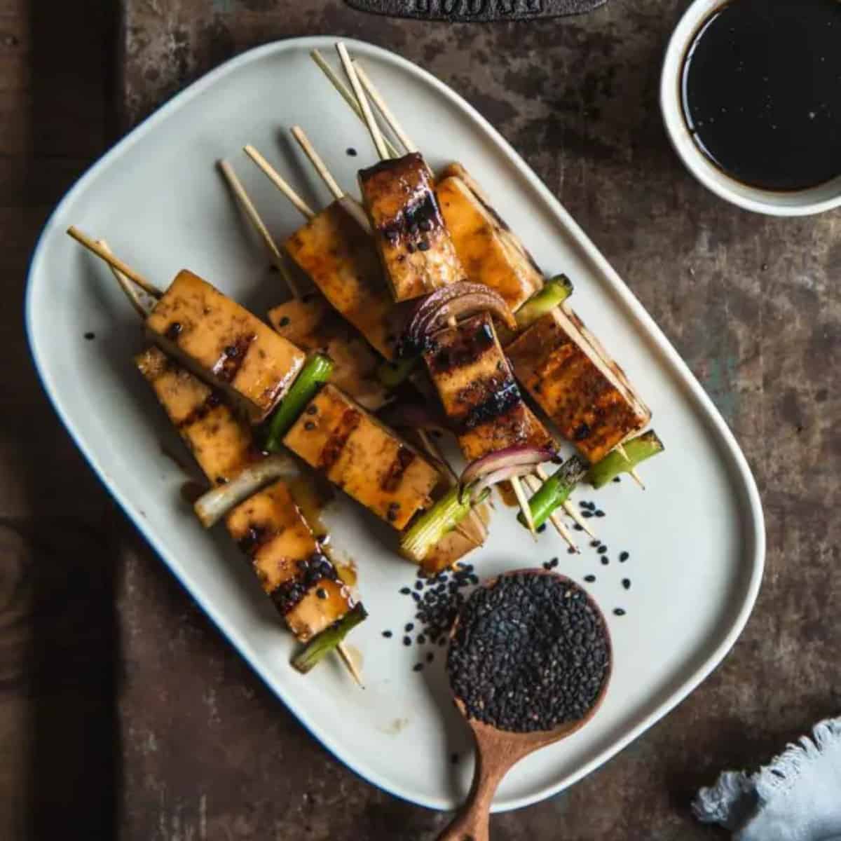 grilled skewers of tofu onions and asparagus with black sesame seeeds.