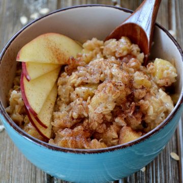 bowl of oatmeal with apples and cinnamon sprinkled over the top.