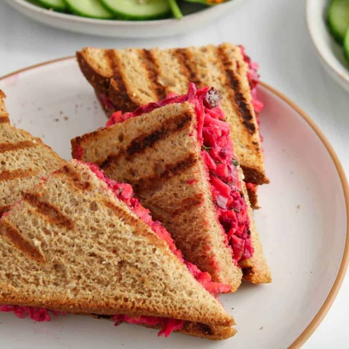 triangle sandwiches filled with bright pink beetroot and pickles.