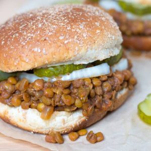hambuger bun with lentils onions and pickles.