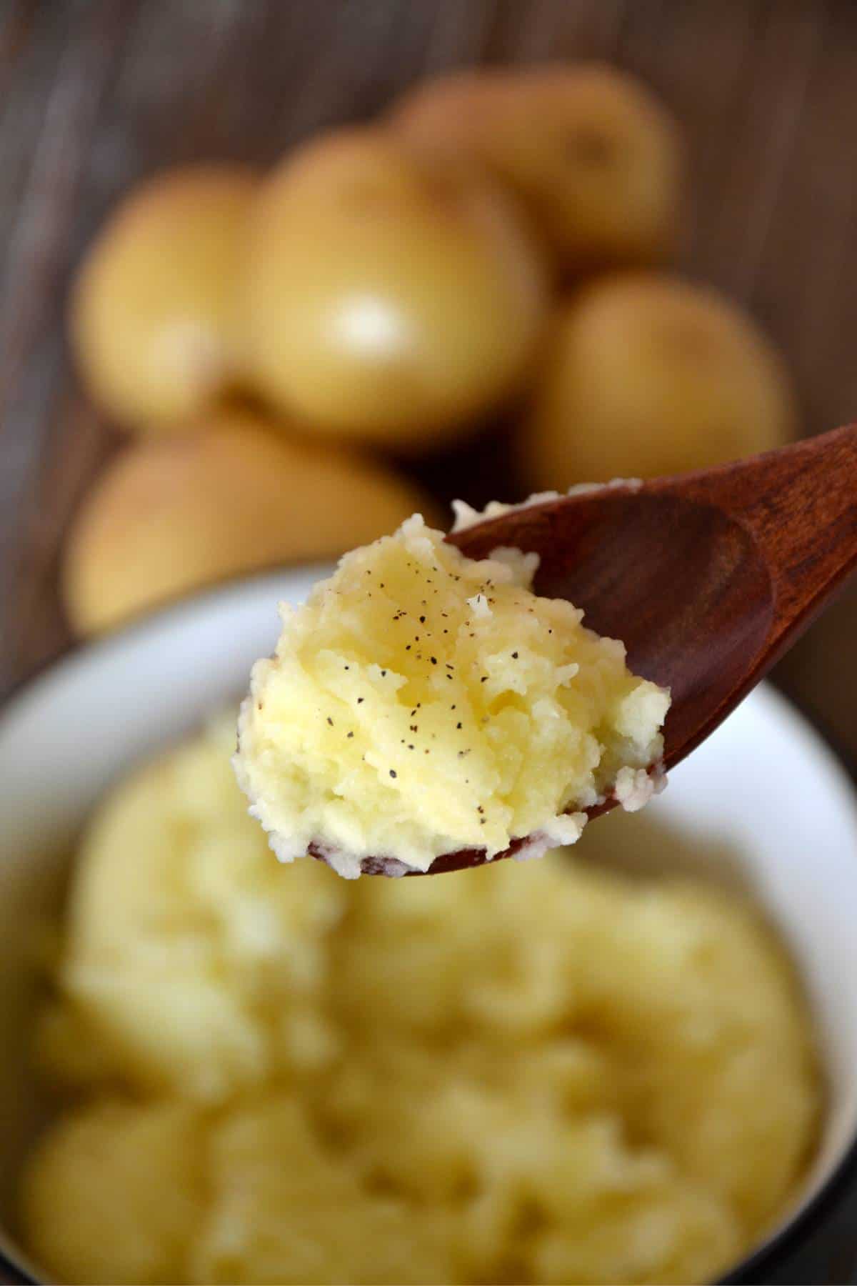 texture of mashed potatoes on wooden spoon.