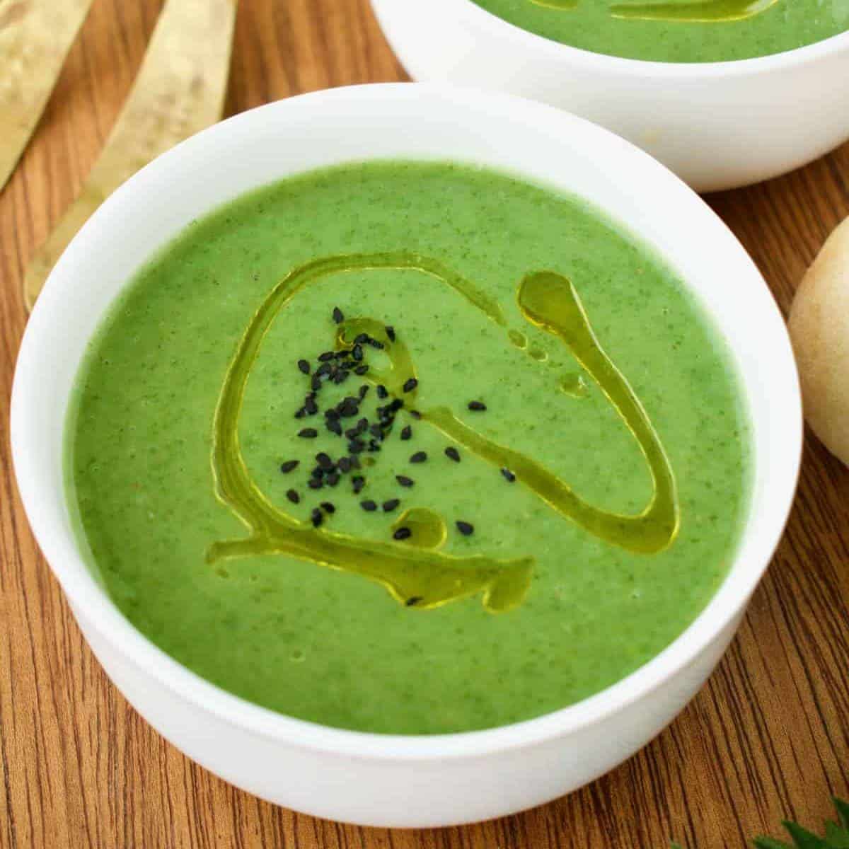 bright green soup topped with black sesame seeds and oil.