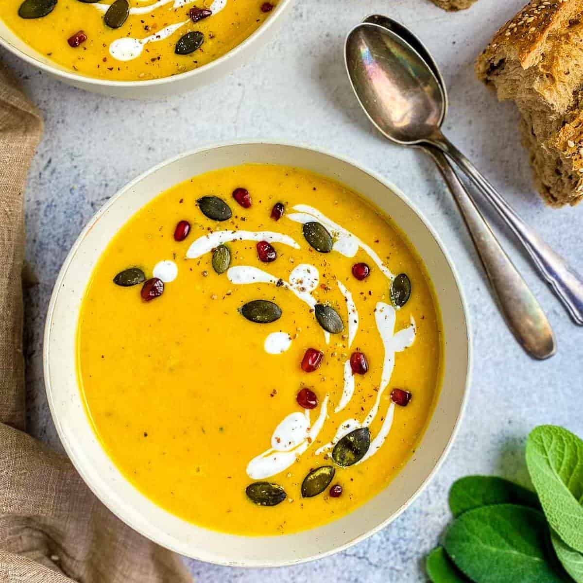 vibrant yellow soup topped with cream and seeds.