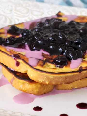 two slices french toast topped with blueberry sauce and compote.
