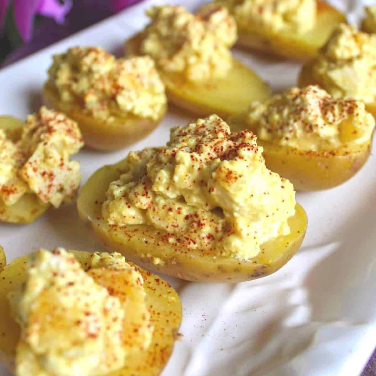 potatoes cut in half and filled with vegan egg salad.