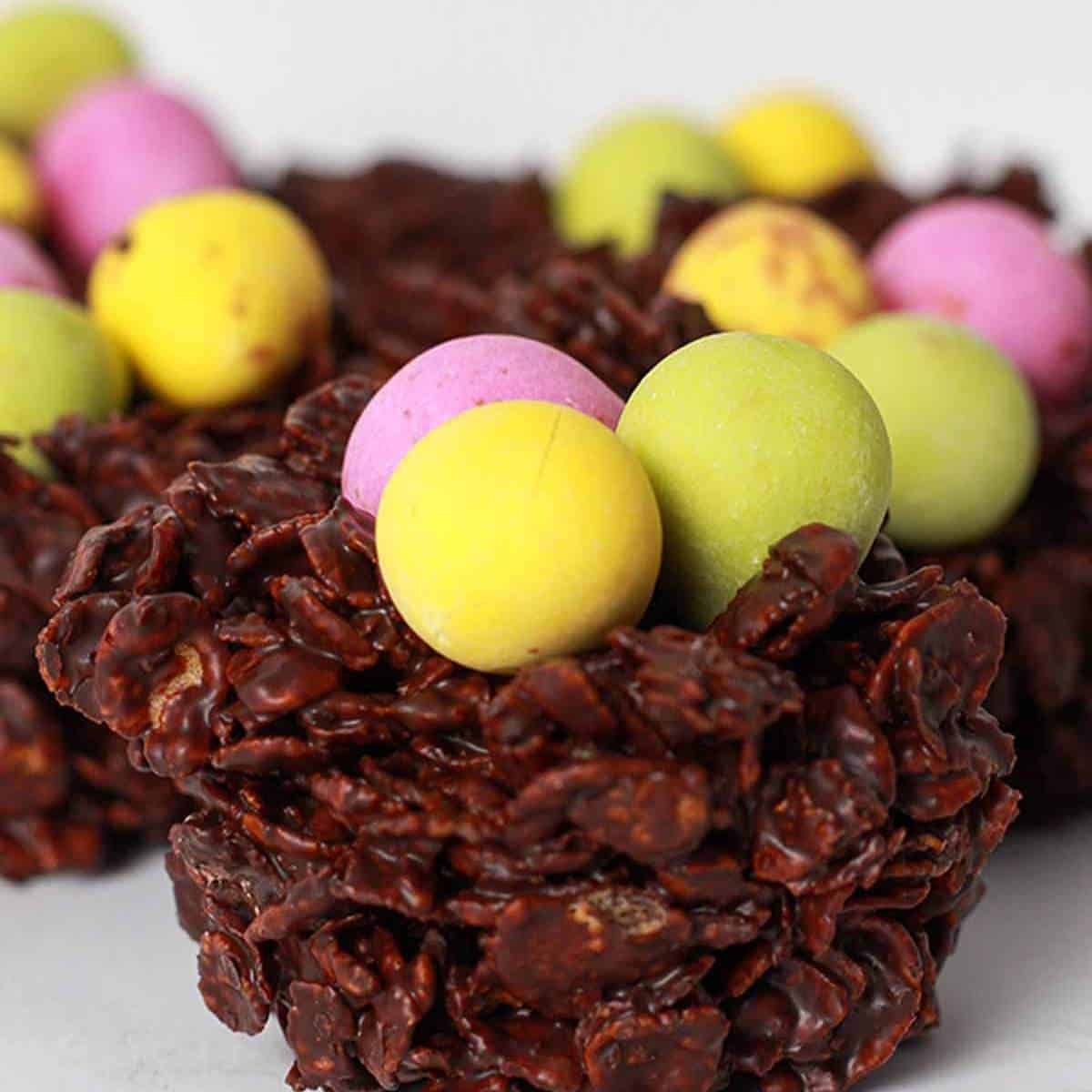 cornflake nests of chocolate holding little candy eggs.