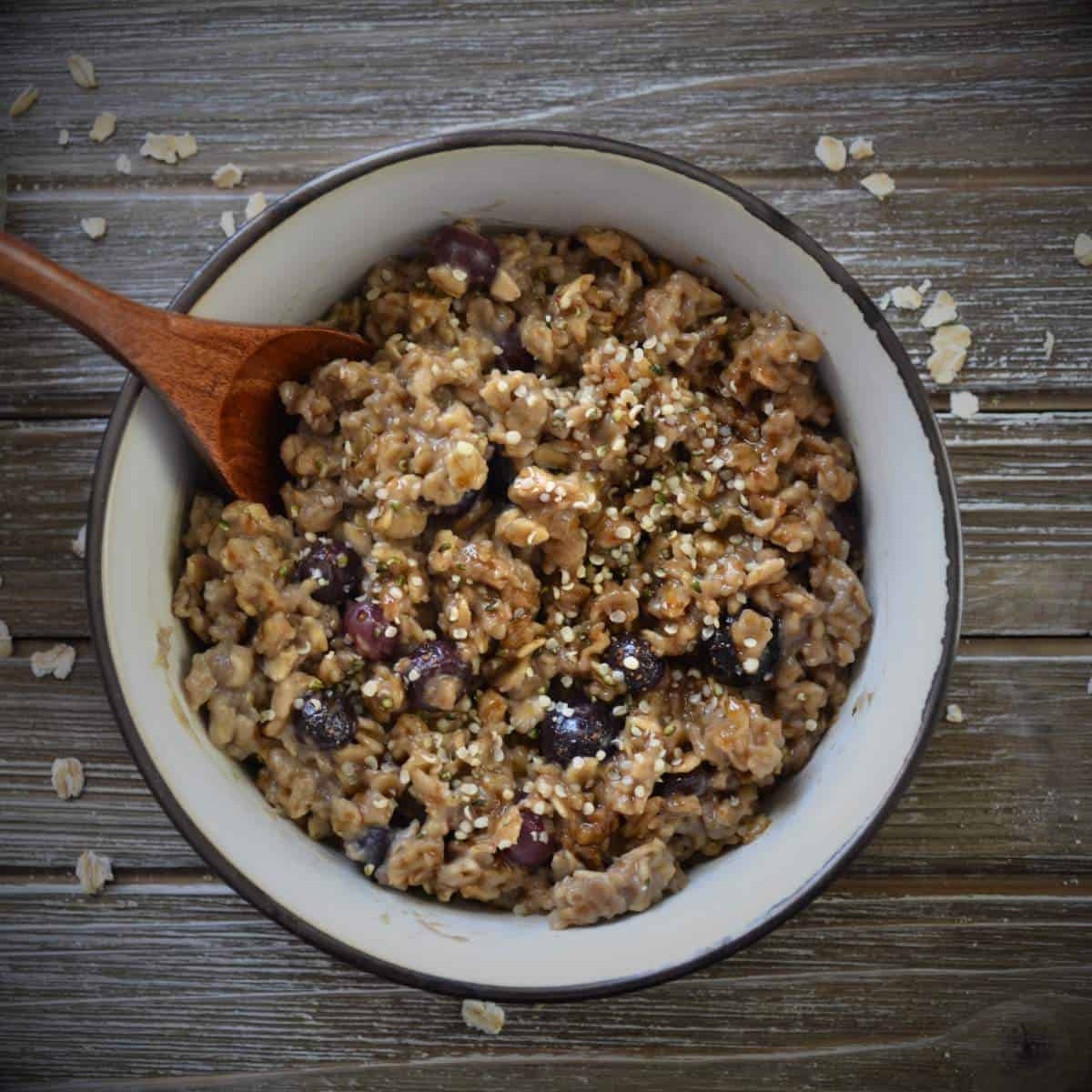 blueberry oatmeal in a bowl with wooden spoon.
